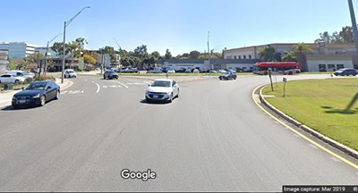 Image of a very wide, large traffic circle with cars entering and cars traveling the circle with no delineated lanes. Drivers are creating their own lanes.