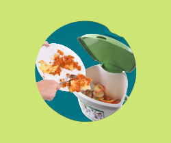 A hand sliding food scraps off a plate into a compost pail.