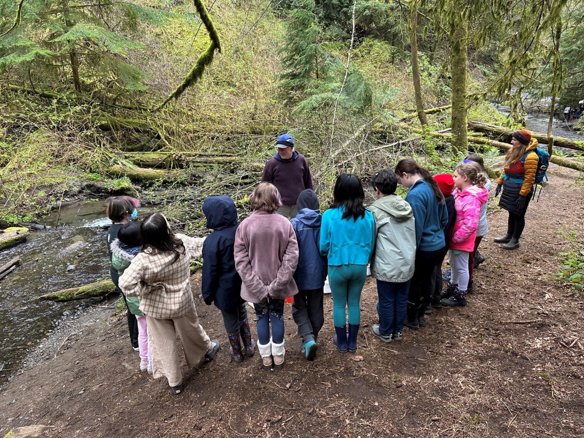 Students gathered around an educator near Boeing Creek.