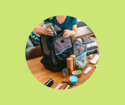 A person making an emergency kit and filling up a backpack with the kit supplies.